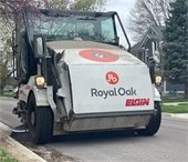 Street sweeping vehicle moving down street 